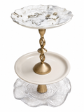 The Loretta tiered serving tray with white floral porcelain top plate, twisted gold metal stem, cream ceramic middle plate, and textured clear glass scalloped base